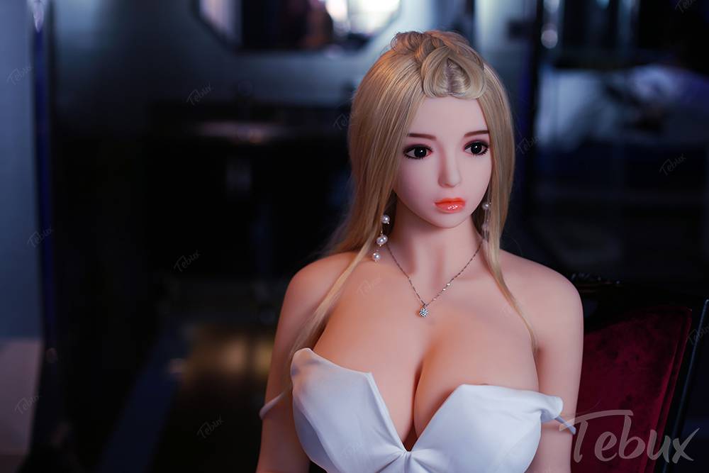 Full size sex doll Alexia sitting in white dress.
