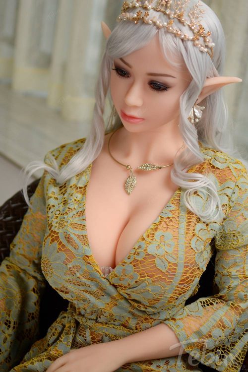 Elf sex doll Holly sitting wearing green dress