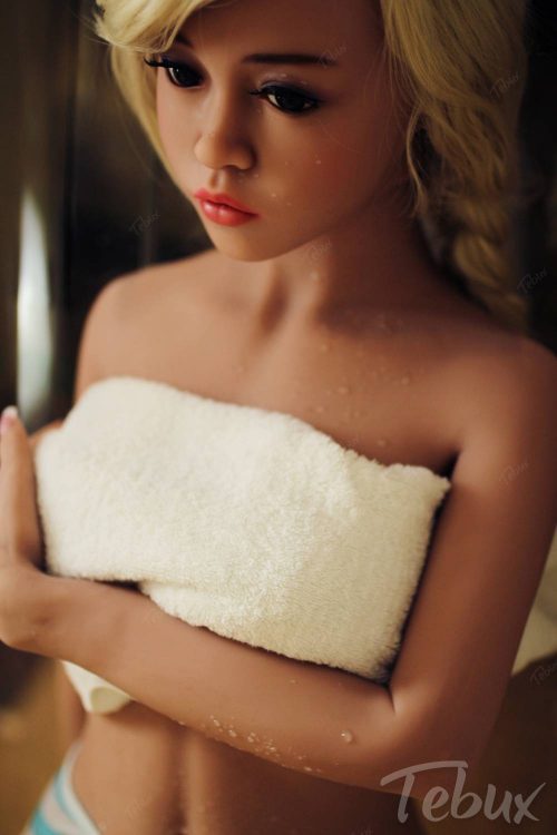 Petite sex doll standing in towel